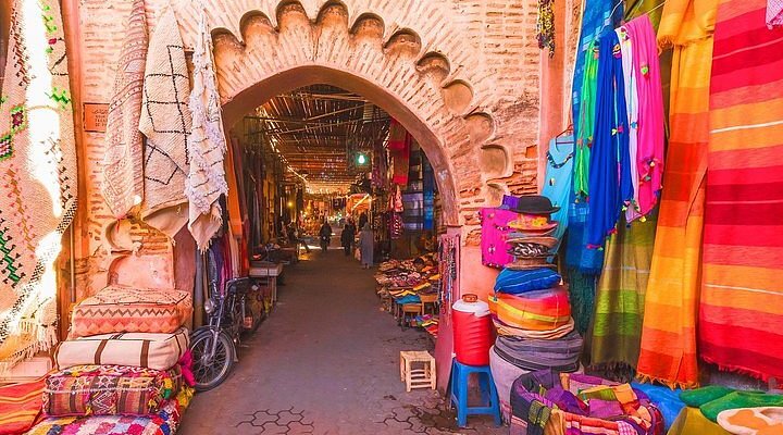 De la place Jamaâ el-Fna, on peut accéder à la Médina de Marrakech avec ses souks colorés et ses produits typiques du Maroc.