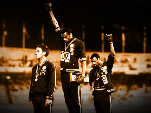 L'Australien Peter Norman sur le podium de 200 m des JO de 1968 à Mexico au moment où Tommie Smith et John Carlos lèvent le poing du Black Power pour protester contre la ségrégation aux Etats-Unis. En soutien, Norman avait porté le badge de l'Olympic Project for the Human Rights. 